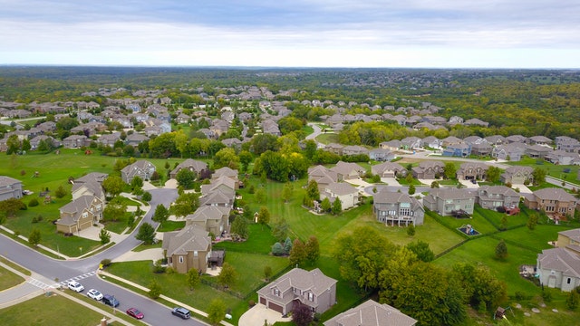 Birds-eye view of a neighborhood with lots of houses and green space
